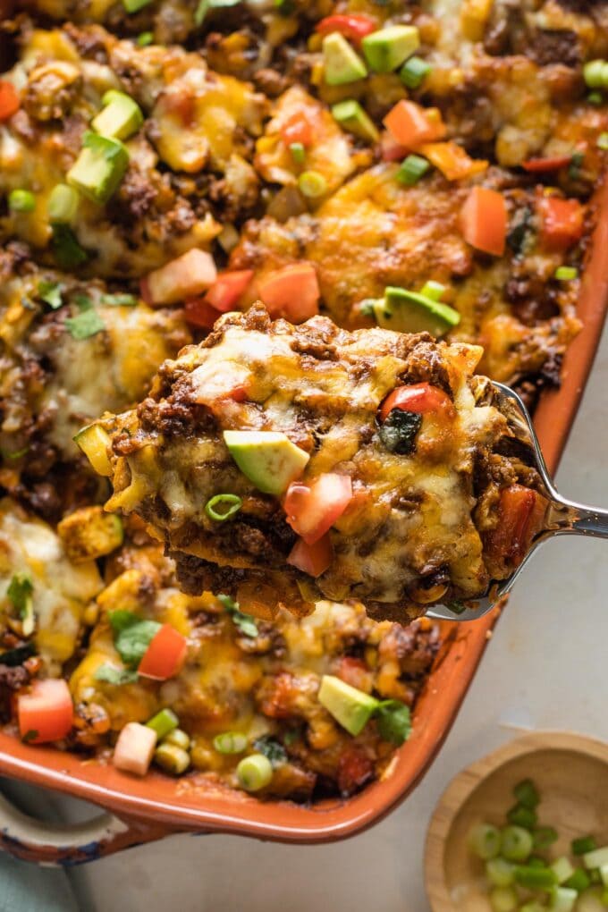 Close up of a square of enchilada casserole being served.