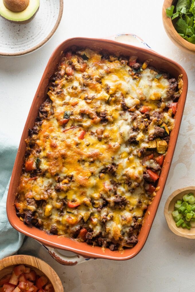 Stacked enchiladas just removed from the oven and cooling in an enameled baking pan.