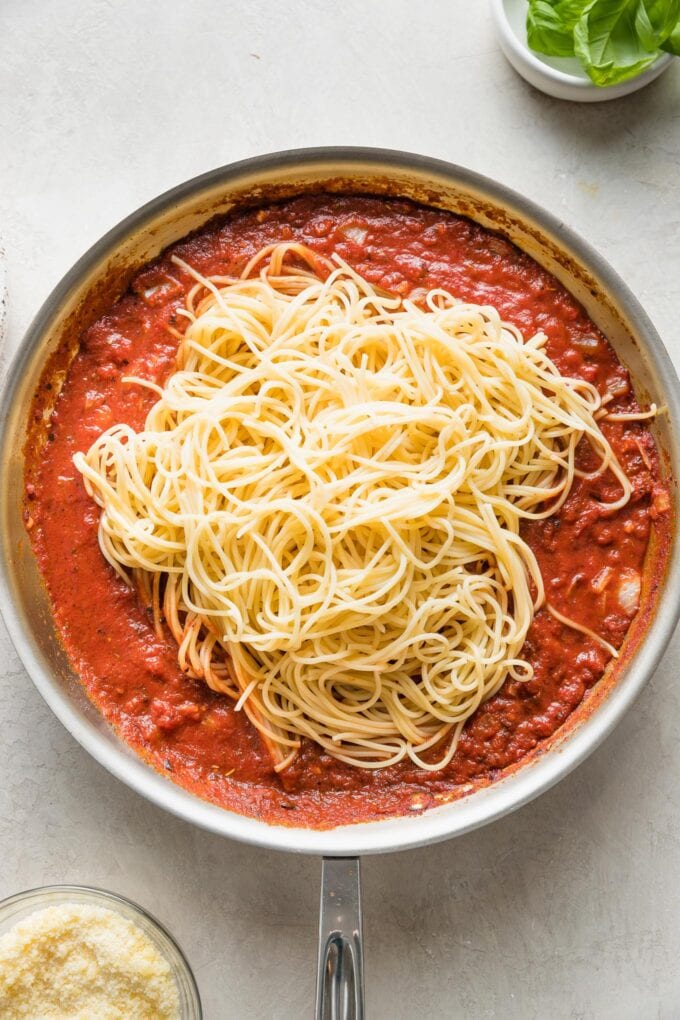 Spaghetti added to tomato sauce.