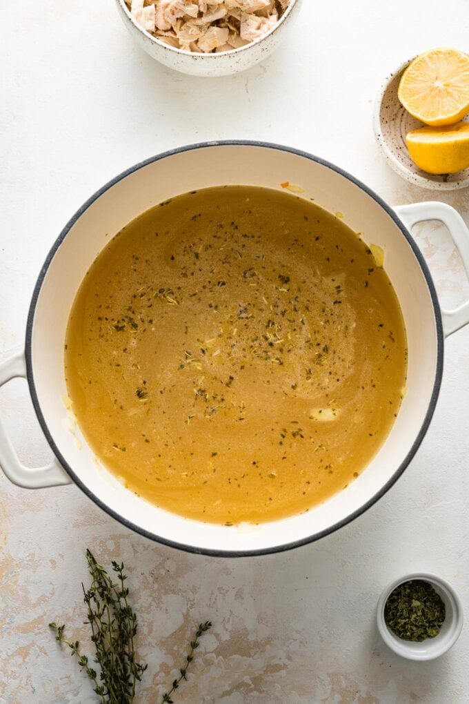 Broth and seasonings added to vegetables in Dutch oven.