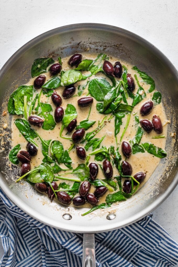 A cream sauce with olives and spinach.