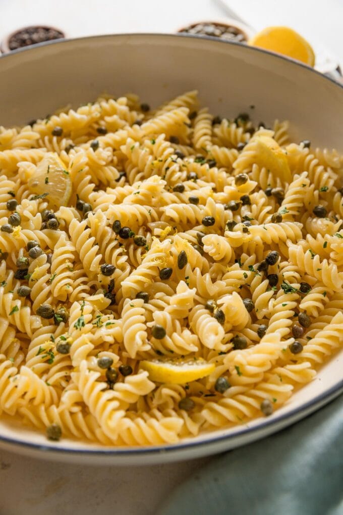 Angled view of lemon caper pasta in a skillet.