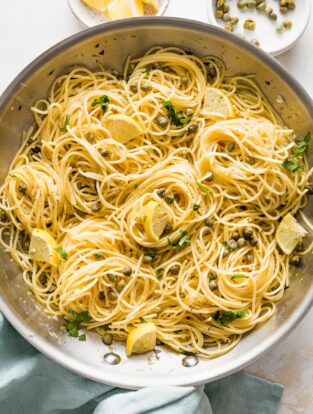 Close-up of a skillet of lemon caper pasta.