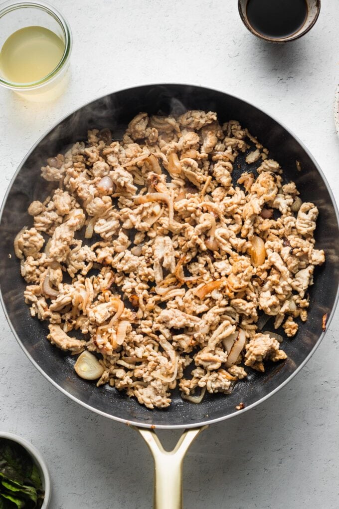 Browned ground chicken in a skillet.