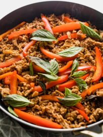 Close up of a Thai-inspired sweet basil chicken dish just cooked in a pan.