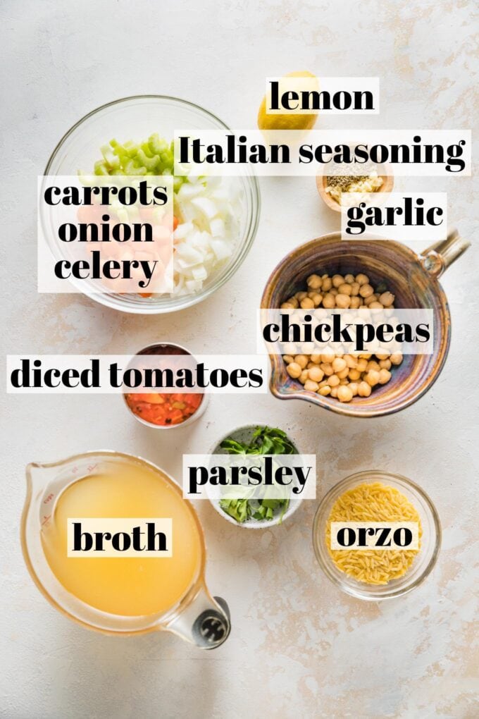 Labeled photo of chickpeas, carrots, onion, celery, lemon, Italian seasoning, garlic, orzo, parsley, diced tomatoes, and vegetable broth in prep bowls.
