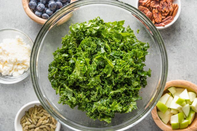 Close-up image of curly kale washed, trimmed of the stems, and massaged with a vinaigrette.