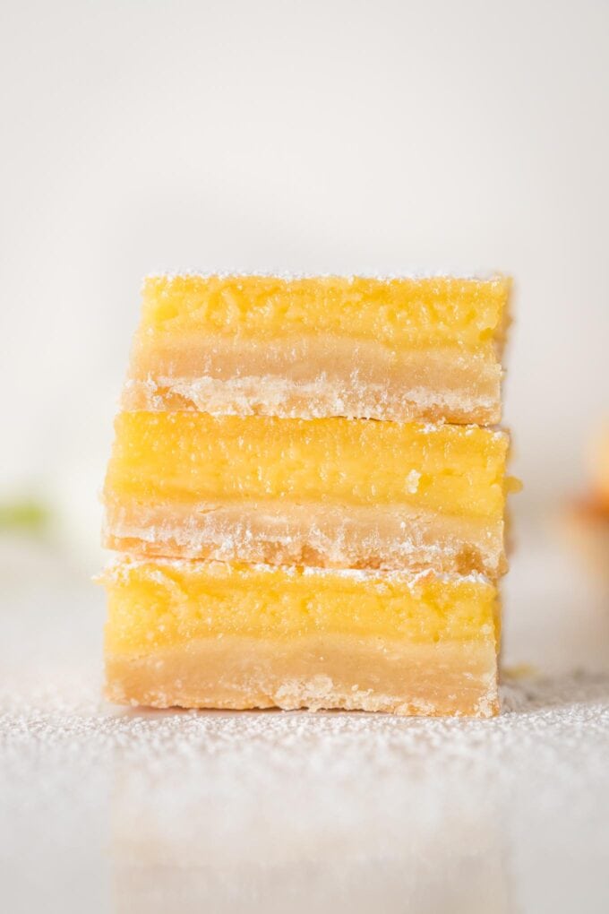 Close-up of three stacked Meyer lemon bars with shortbread crust.
