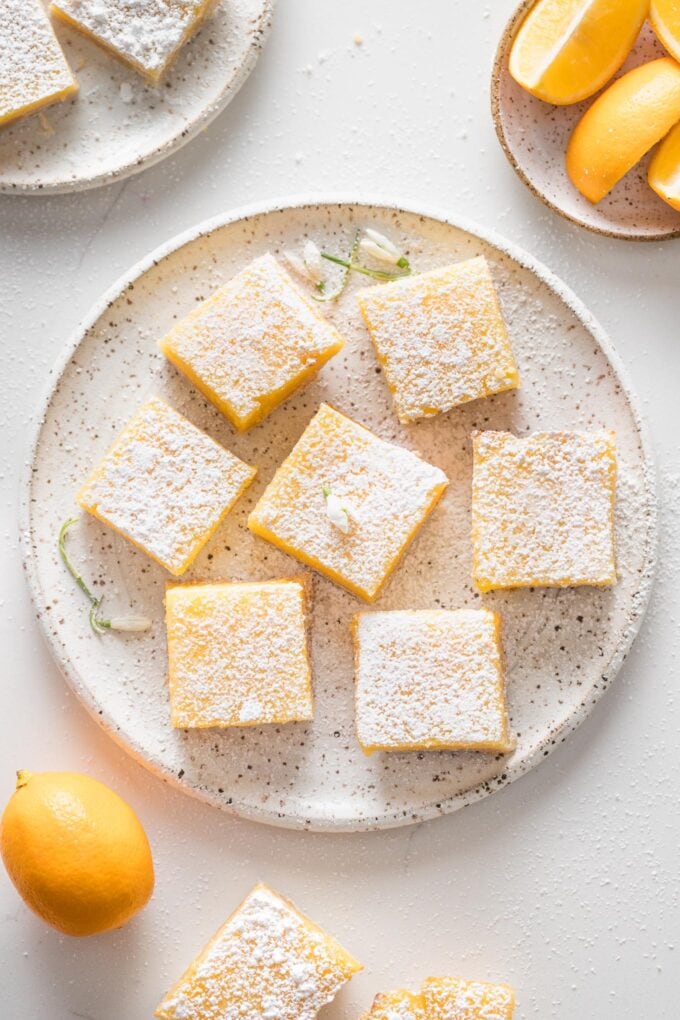 Overhead image of a white ceramic plate with Meyer lemon bars ready to serve.