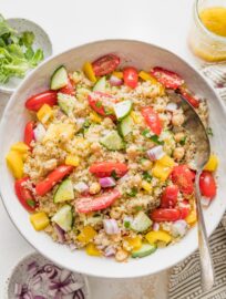 Serving spoon ready to portion out quinoa chickpea salad.