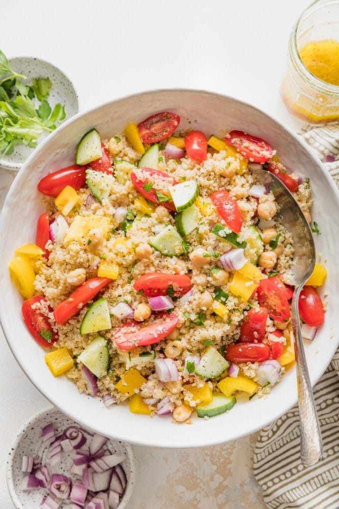 Serving spoon ready to portion out quinoa chickpea salad.