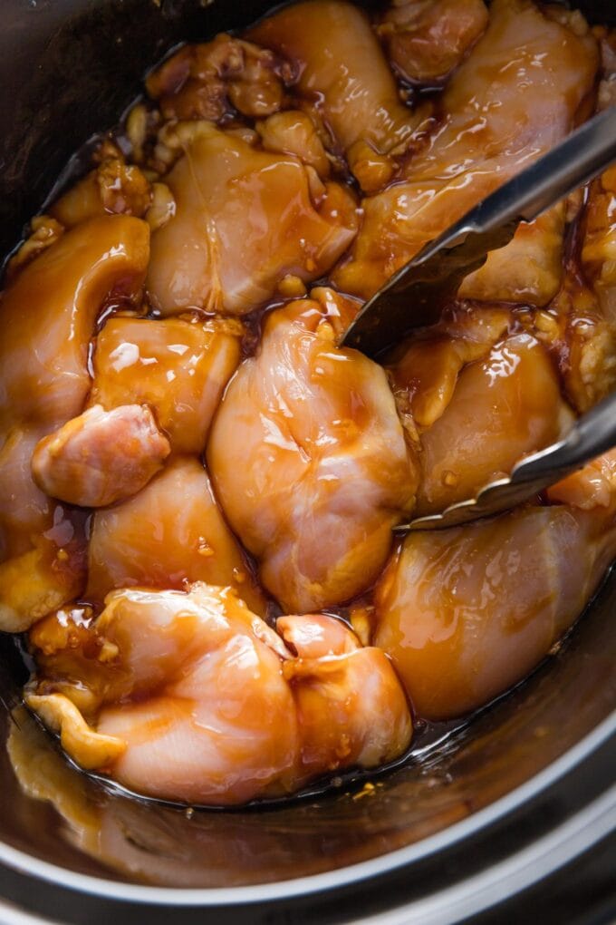 Chicken thighs in a slow cooker covered in homemade teriyaki sauce.