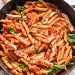 Cast iron skillet filled with chicken marinara pasta ready to serve.