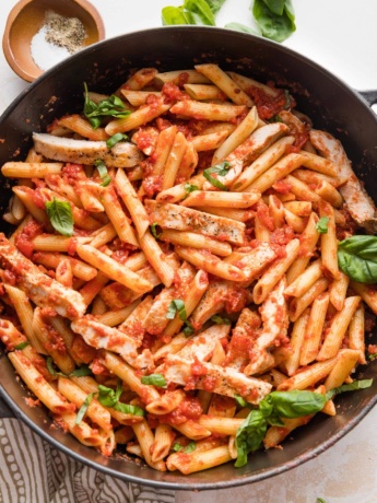 Cast iron skillet filled with chicken marinara pasta ready to serve.