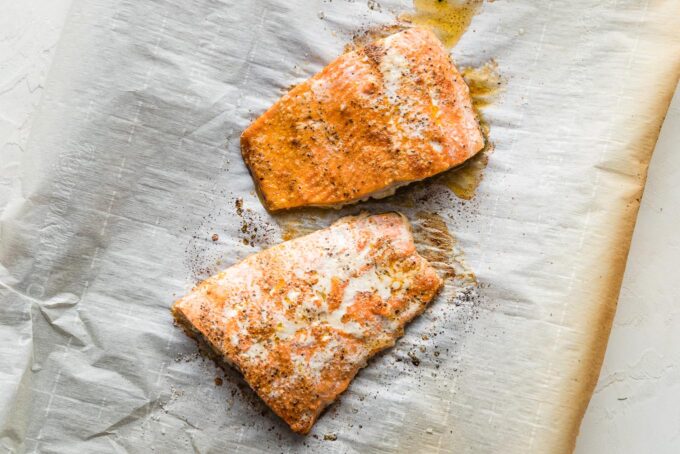 Cooked salmon fillets on parchment paper.