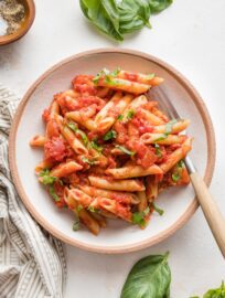 Small wooden bowl filled with a serving of homemade pasta marinara.