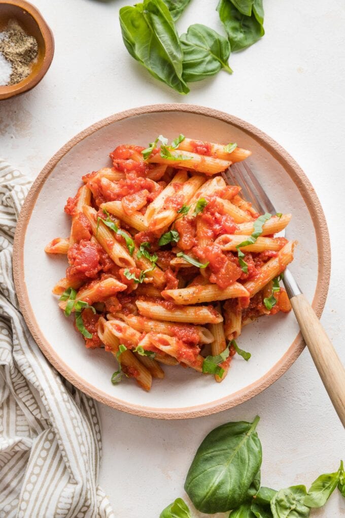 Small wooden bowl filled with a serving of homemade pasta marinara.