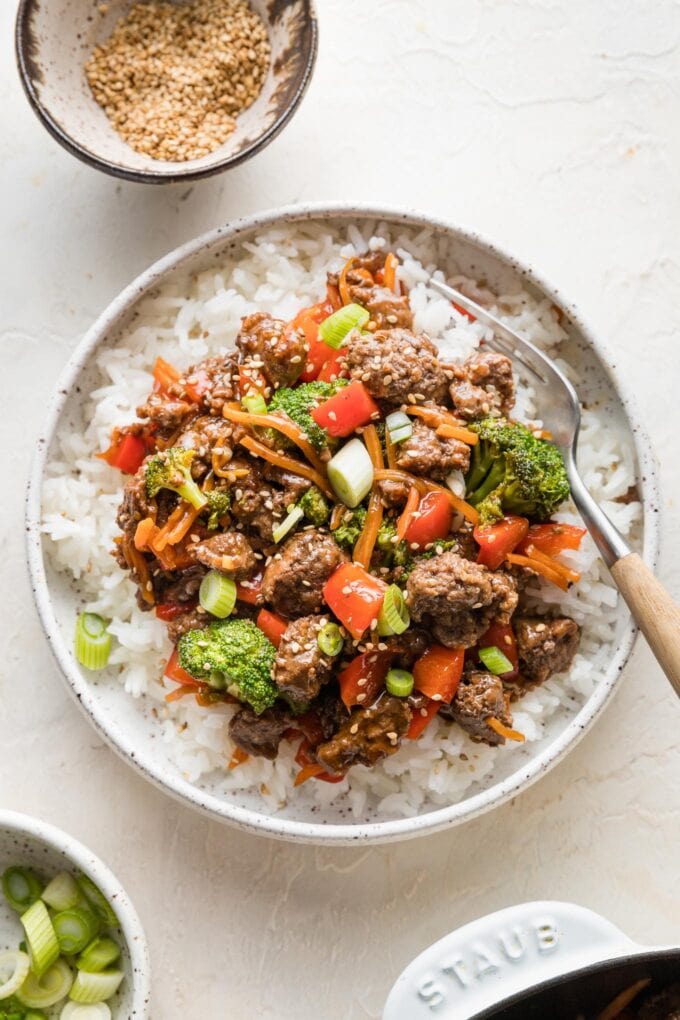 Small bowl of teriyaki ground beef over white rice with a fork.