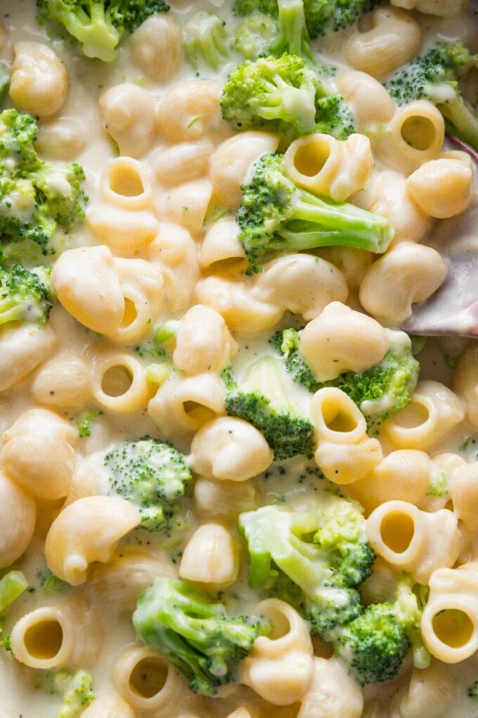 Close up of creamy broccoli mac and cheese, stirred together but unbaked.