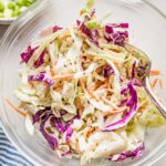 Clear serving bowl full of a healthy homemade coleslaw ready to eat.