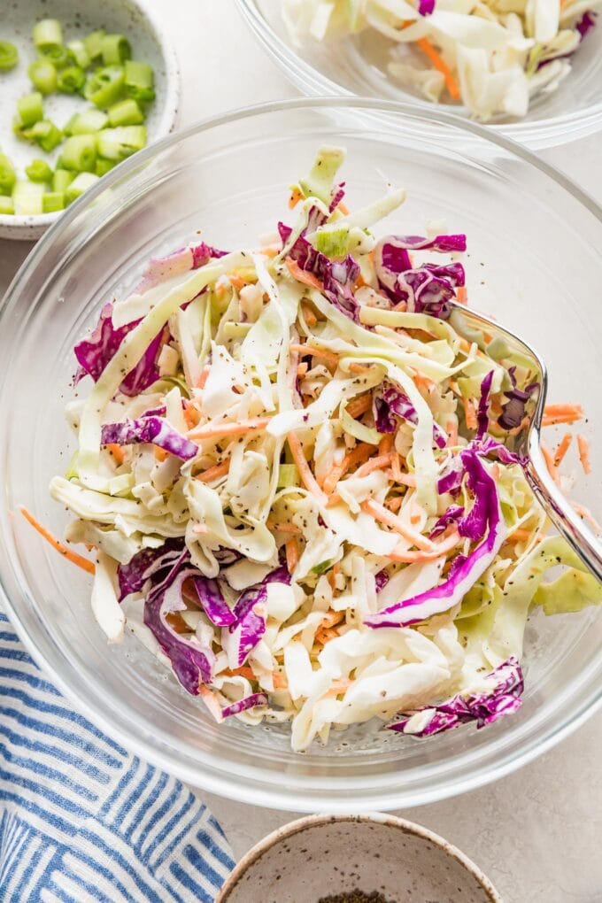 Clear serving bowl full of a healthy homemade coleslaw ready to eat.