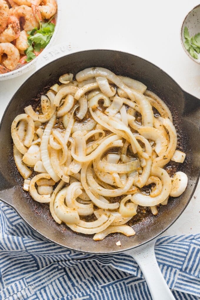 Sweet onions sliced into long strips and cooked in butter in a skillet.