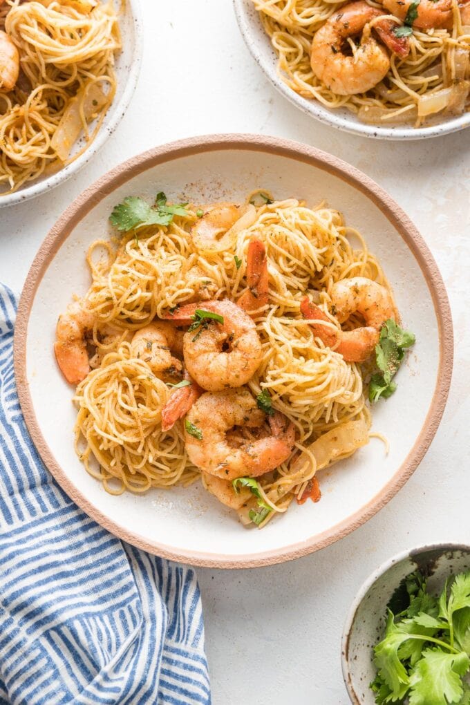 Small pasta bowl filled with a serving of jerk shrimp pasta garnished with parsley and ready to eat.