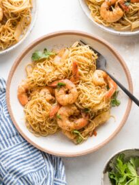 Small pasta bowl filled with a serving of jerk shrimp pasta garnished with parsley and ready to eat.