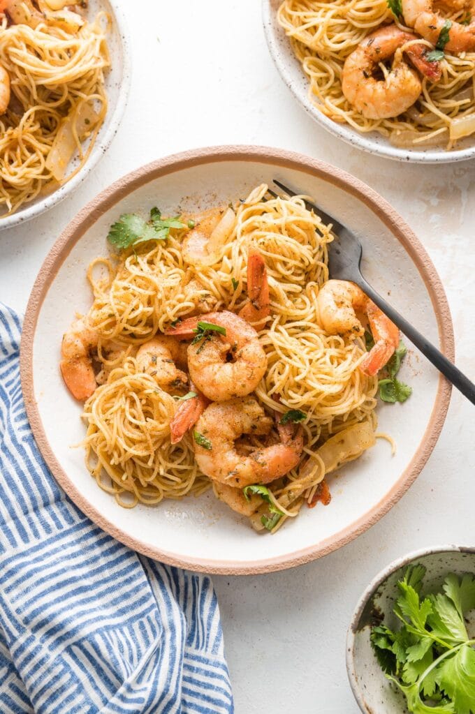 Small pasta bowl filled with a serving of jerk shrimp pasta garnished with parsley and ready to eat.