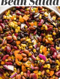 A large Mexican three bean salad with homemade cilantro vinaigrette, in a white bowl ready to serve.