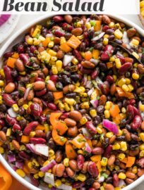 A large Mexican three bean salad with homemade cilantro vinaigrette, in a white bowl ready to serve.