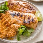 45 degree angle view of a chicken breast cooked with a Baja style marinade with grill marks.