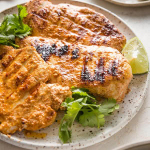 45 degree angle view of a chicken breast cooked with a Baja style marinade with grill marks.