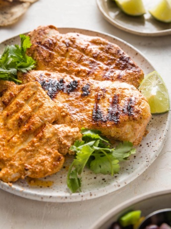 45 degree angle view of a chicken breast cooked with a Baja style marinade with grill marks.