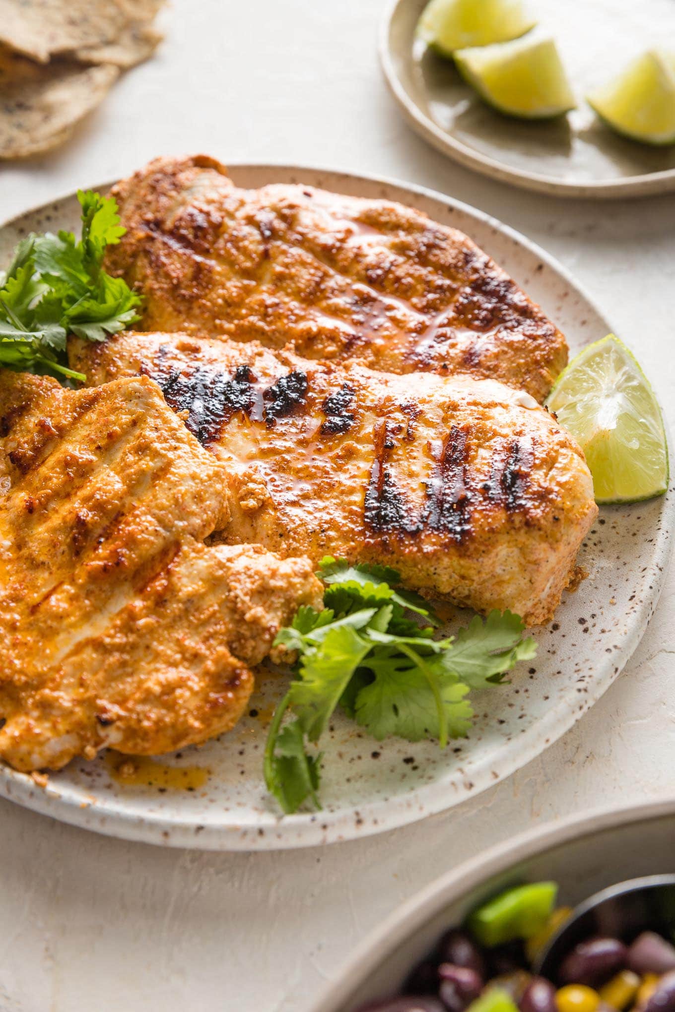 45 degree angle view of a chicken breast cooked with a Baja style marinade with grill marks.