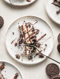 Close up of a fork slicing off a bite of layered Oreo ice cream cake.