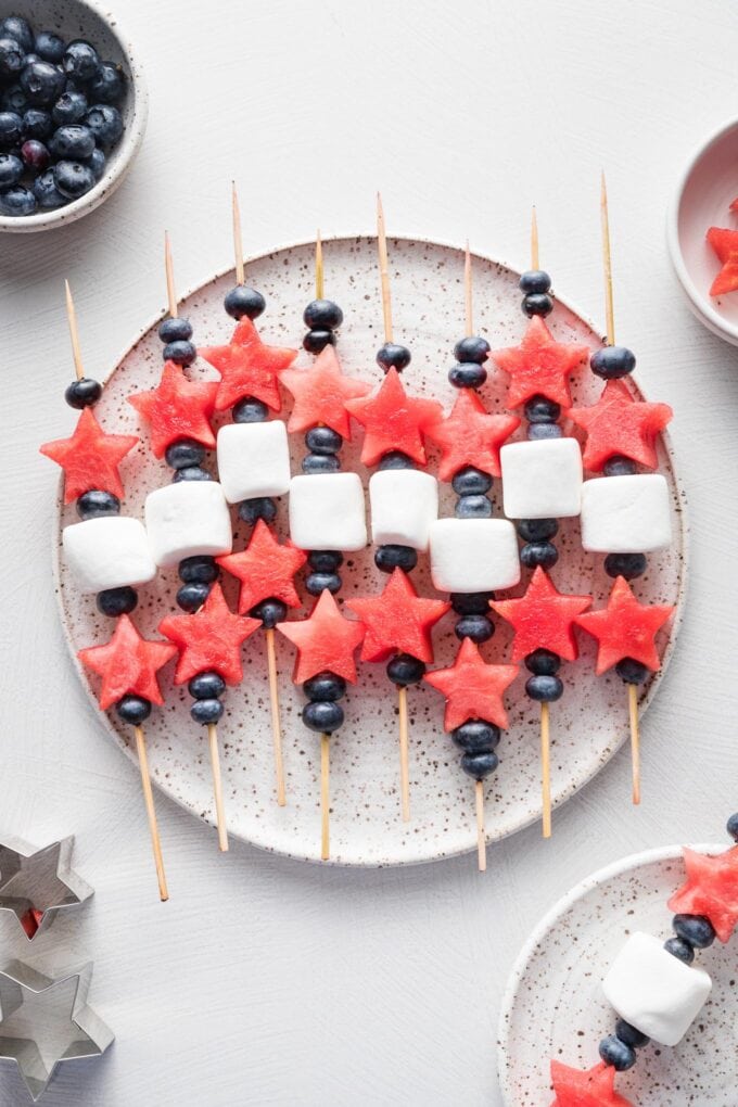 Platter filled with watermelon, blueberry, and marshmallow-laced bamboo skewers.