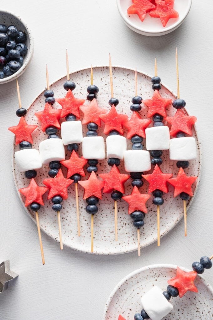 Platter filled with watermelon, blueberry, and marshmallow-laced bamboo skewers.