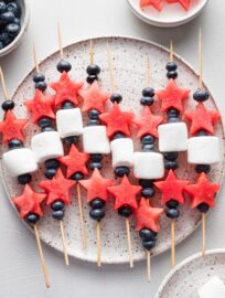 Platter filled with watermelon, blueberry, and marshmallow-laced bamboo skewers.