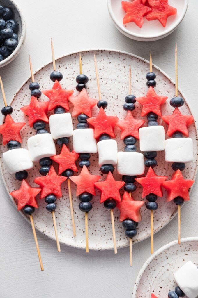 Platter filled with watermelon, blueberry, and marshmallow-laced bamboo skewers.