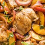 Close up of a chicken thigh cooked with peaches and balsamic vinegar.