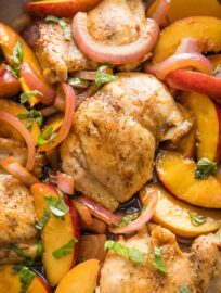 Close up of a chicken thigh cooked with peaches and balsamic vinegar.