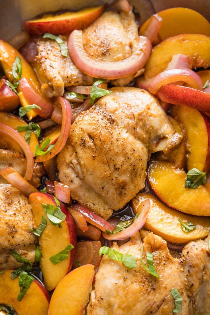 Close up of a chicken thigh cooked with peaches and balsamic vinegar.