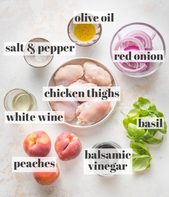 Labeled overhead image of chicken thighs, sliced red onion, yellow peaches, fresh basil, white wine, balsamic vinegar, olive oil, kosher salt and black pepper, all measured into prep bowls and ready to cook.
