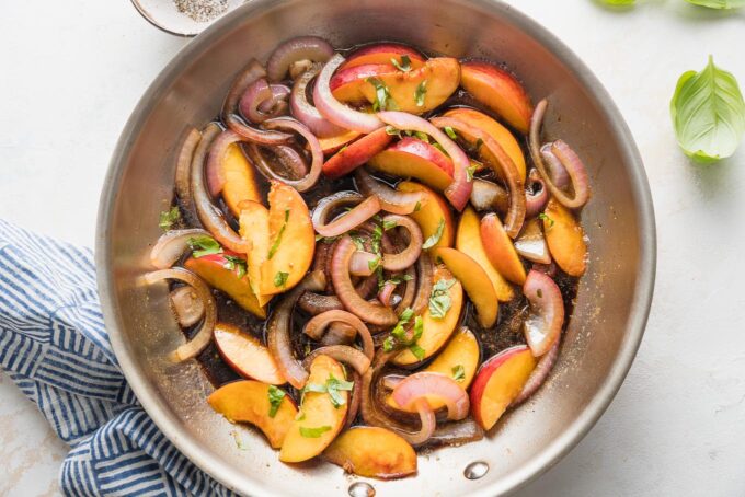 Skillet with peaches, red onions, and balsamic sauce.