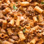 Close up of ground beef pasta with Parmesan in a skillet.