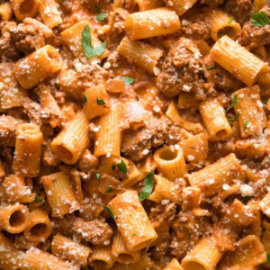 Close up of ground beef pasta with Parmesan in a skillet.