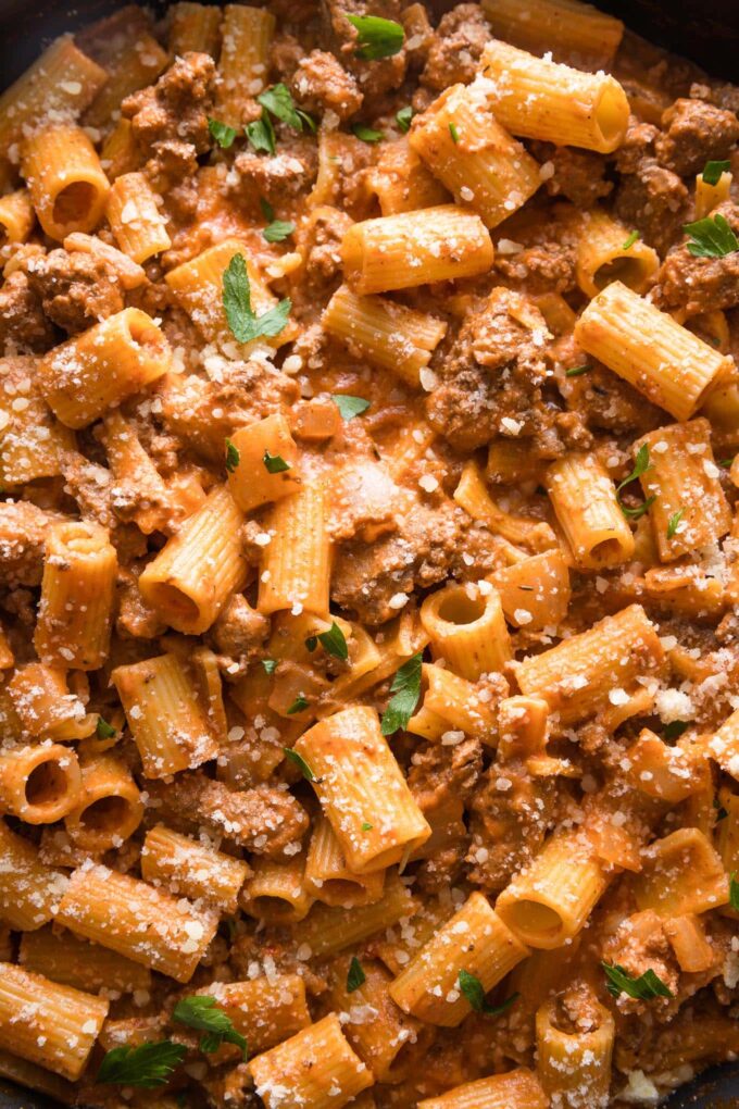 Close up of ground beef pasta with Parmesan in a skillet.