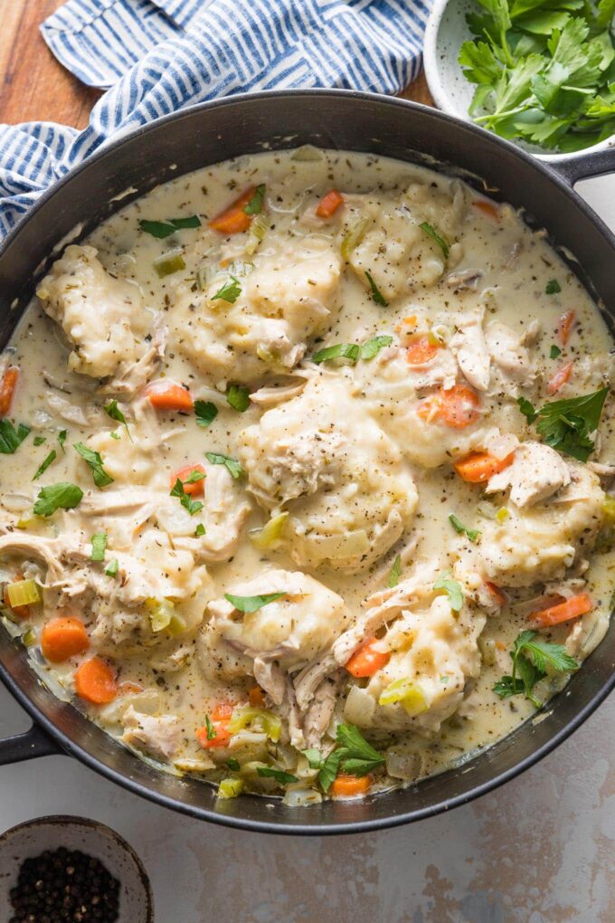 Overhead view of a large cast iron skillet full of chicken and dumplings.