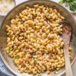 Skillet filled with a creamy cavatappi pasta with Parmesan and sun-dried tomatoes.